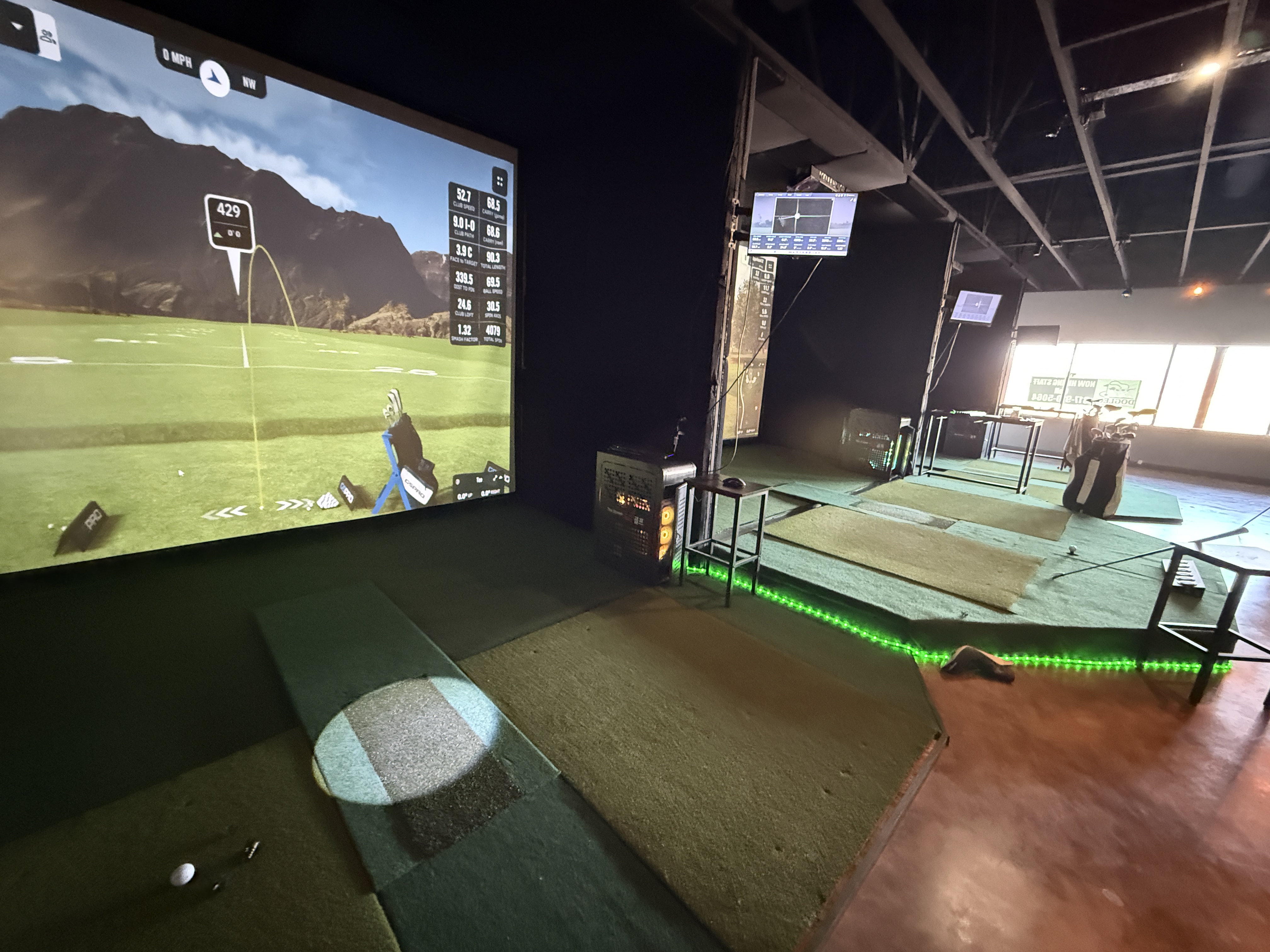 GSPro simulator software running on large screen with shot stats